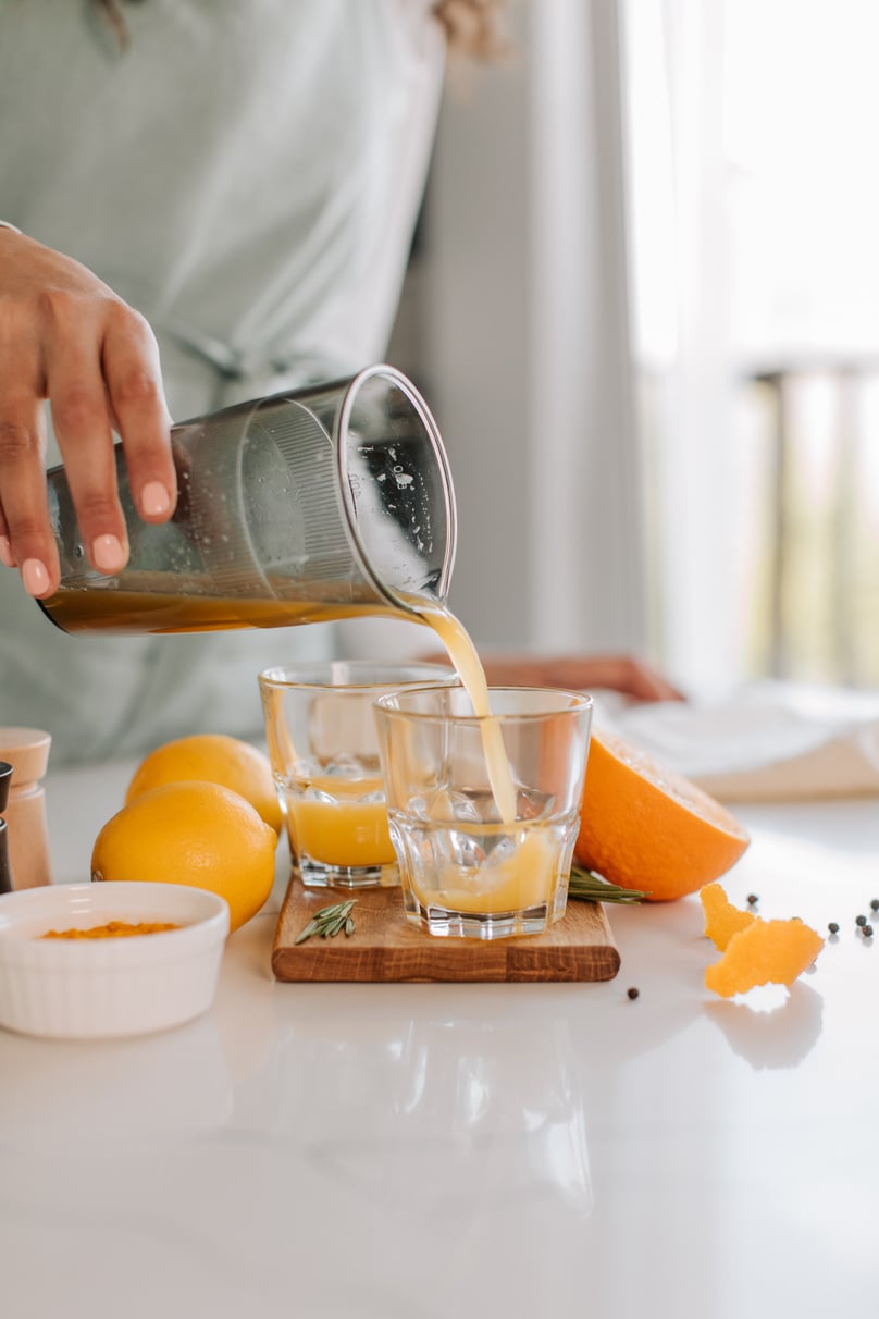 Woman Pouring  Homemade Orange Juice